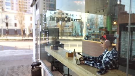 mujer joven trabajando en una computadora portátil en un café