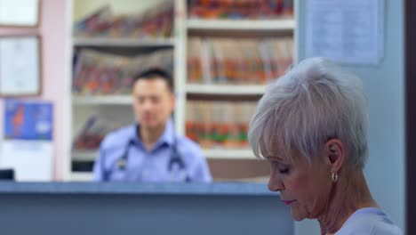 side view of caucasian senior patient using mobile phone at clinic 4k