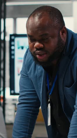 vertical video diverse office coworkers reviewing monthly data graphs to create reports