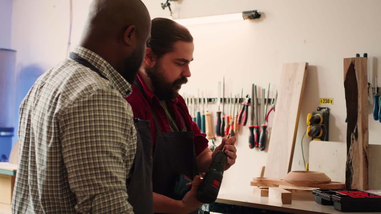 ebanista enseñando a un aprendiz a perforar un agujero en un bloque de madera