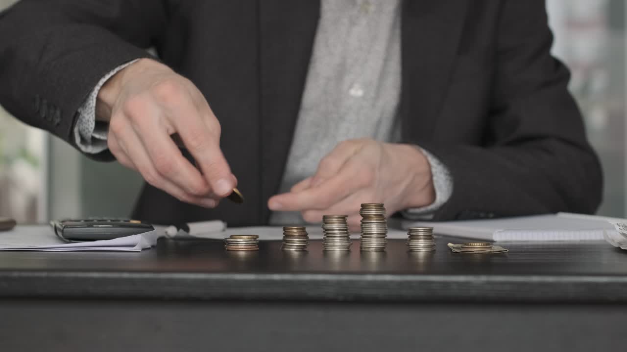 남자 손으로 동전을 쌓고 테이블에서 세고