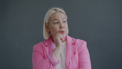 thoughtful woman in pink blazer