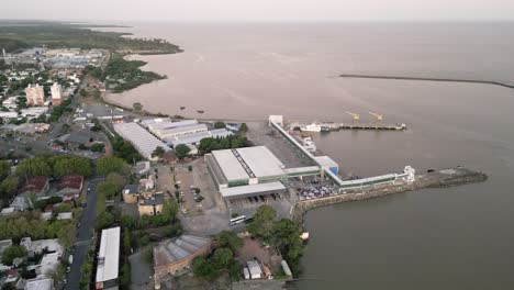 Aerial-view-flying-over-Colonia-del-Sacramento-coastal-harbour-breakwater-on-the-Uruguay-coastline