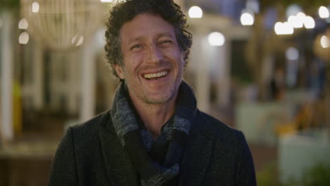 portrait attractive mature man laughing enjoying relaxed urban evening in city wearing warm fashion slow motion