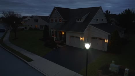 large american home during blue hour dusk with street light and lights on house