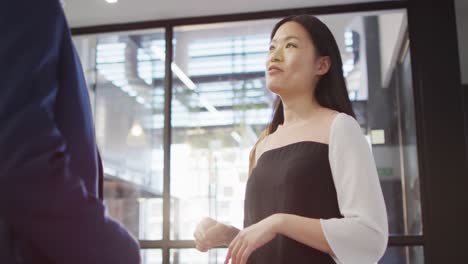 two diverse businesspeople discussing together and standing at table