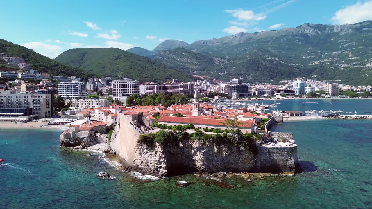 Old town of Budva on the Adriatic coast and mountains in background, Drone shot