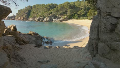 Die-Kamera-Bewegt-Sich-Vorwärts-Und-Zeigt-Einen-Exotischen-Strand-Mit-Ruhigen-Wellen,-Die-Ins-Ufer-Rollen