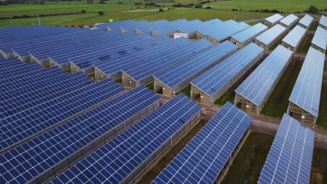 blue solar panel array with thousands of solar panels on roofs of greenhouses