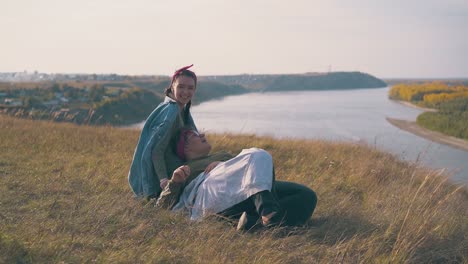 woman with girlfriend spends time in camp against river