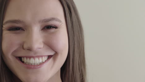 Primer-Plano-Retrato-Hermosa-Joven-Mujer-Caucásica-Sonriendo-Feliz-Disfrutando-Del-éxito-Satisfacción-Mujer-Bonita-Sobre-Fondo-Liso