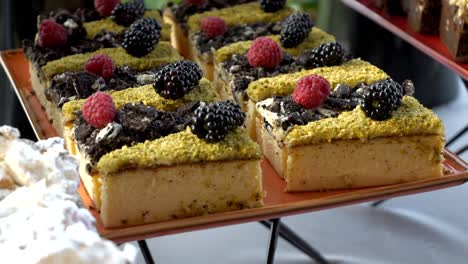 cheesecake slices with crumbly topping, blueberries, and raspberries arranged on a plate