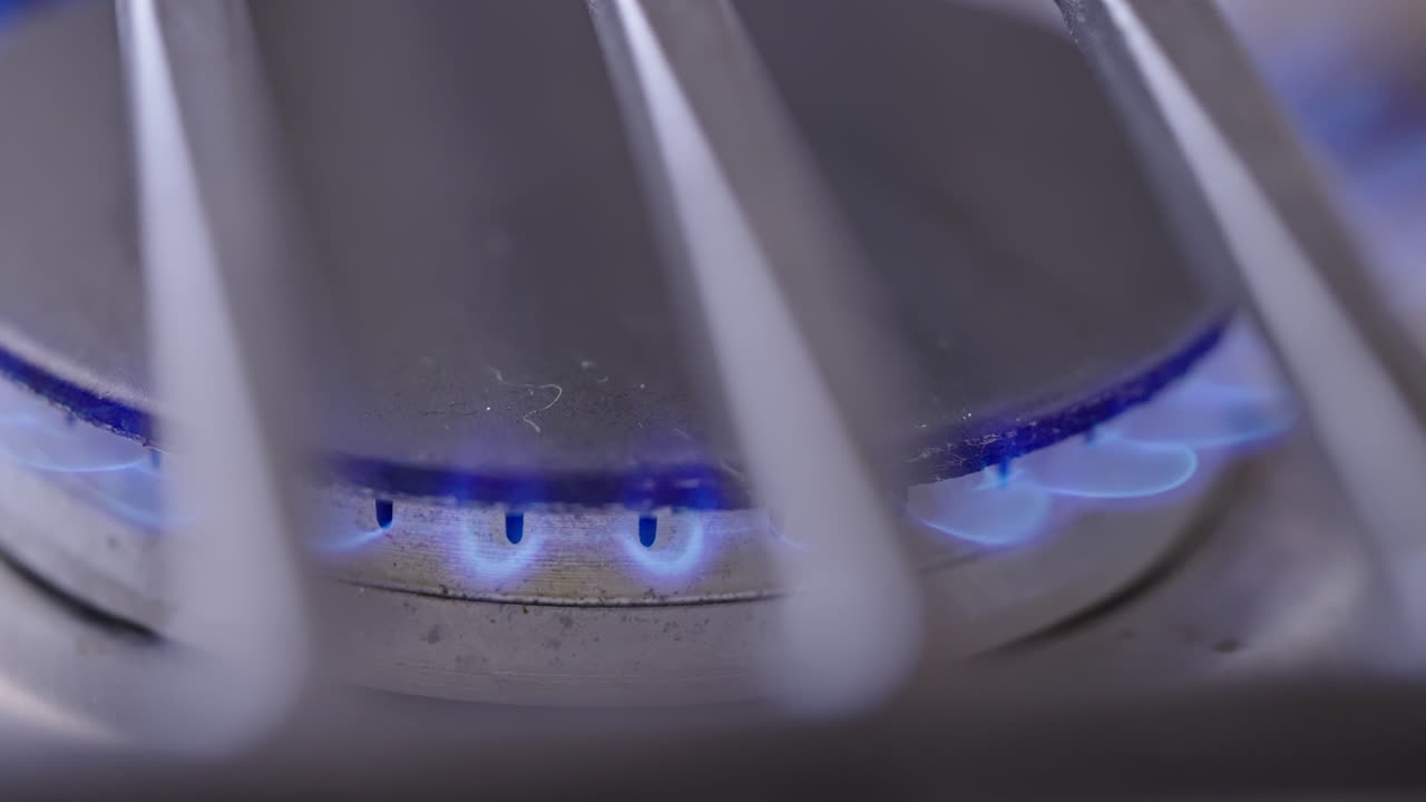 Close-up of a gas stove burner with blue flames