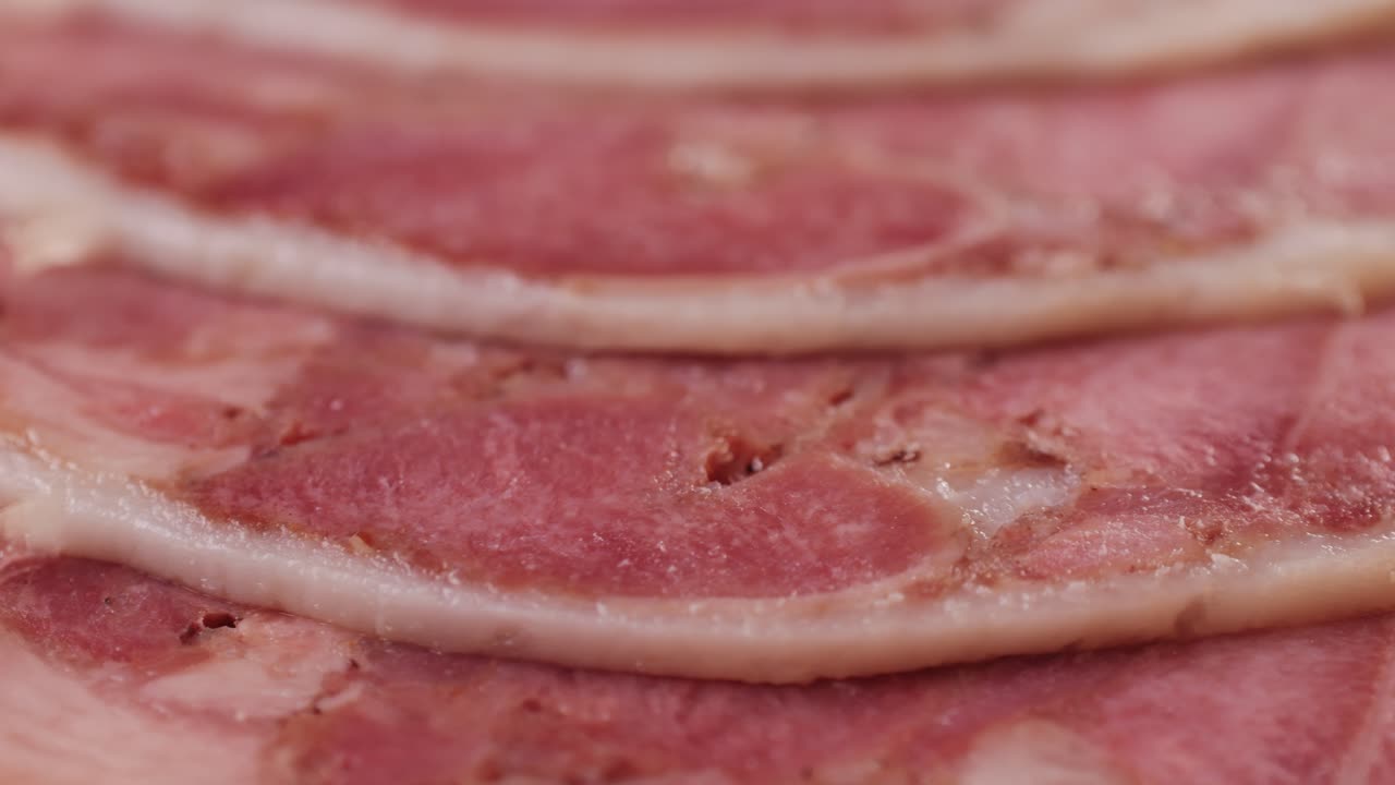 black bull sausage ham, tongue pork dry-cured sausage on a black background, traditional spanish delicatessen food, close up.