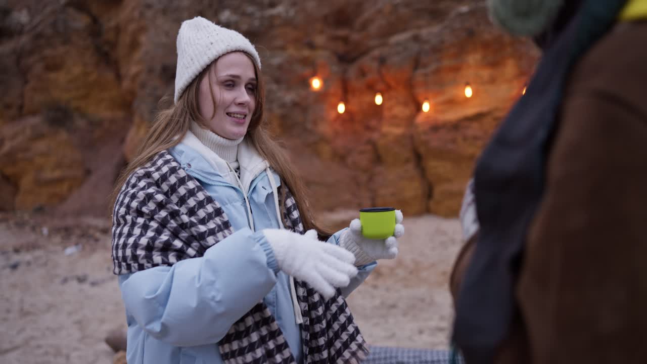 Woman enjoying a hot drink on a winter beach