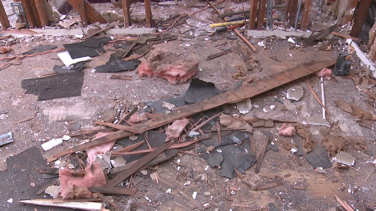 철거되는 과정에서 집의 문과 부서지는 벽을 확대하기 위해 잔해로 덮인 바닥에서 위로 기울입니다.