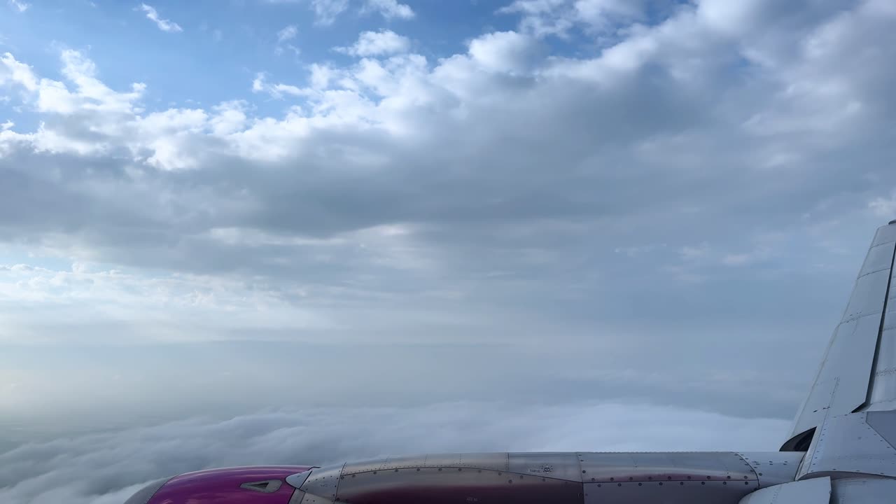 Airplane wing with blue sky and clouds, serene travel concept