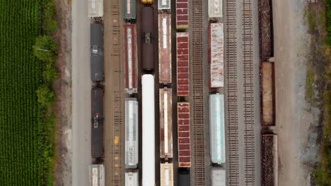 4k-top-down-view-moving-from-top-to-bottom-showing-multiple-trains-while-parked-at-a-train-station