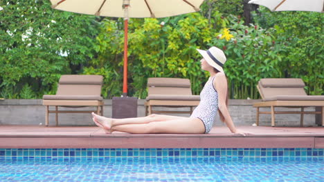 woman sitting by the pool, relaxing on the poolside deck