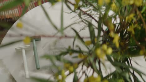 Razor-blades-on-marble-coffee-table-through-plants-and-flowers