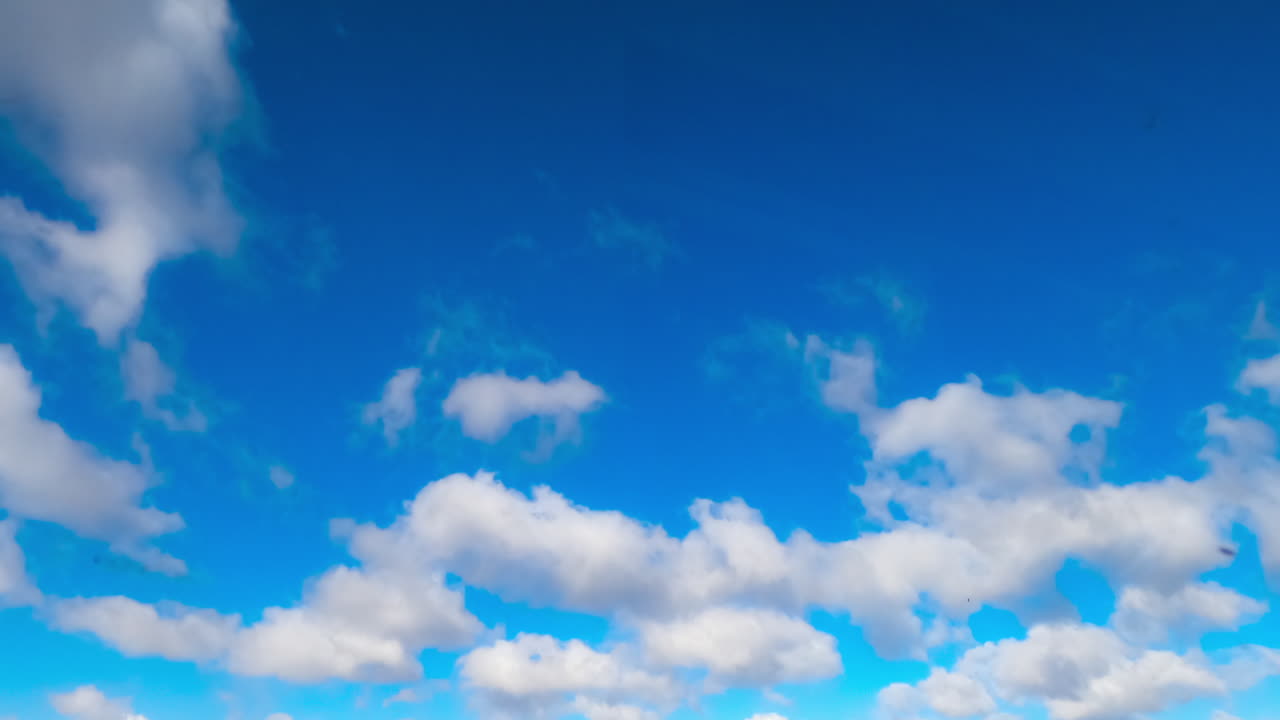 Fantastic azure sky with white clouds flying quickly by. Summer sky timelapse. Low angle view.