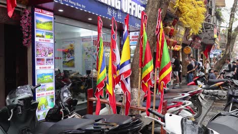 busy street with motorbikes and colorful flags