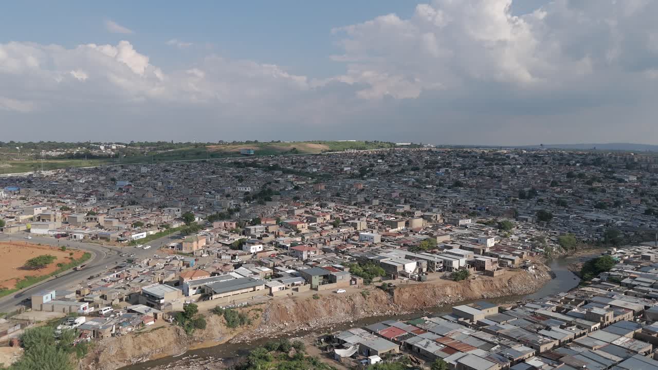 el dron de avance lento captura la vasta extensión de un gran municipio urbano en johannesburgo, con el río jukskei fluyendo a través, proporcionando una perspectiva dinámica de la vida urbana y los elementos naturales