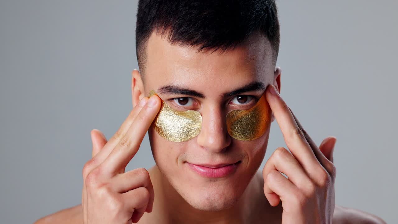 Man applying gold eye patches