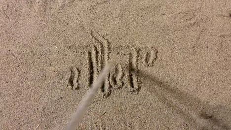 writing a message in the sand with a stick