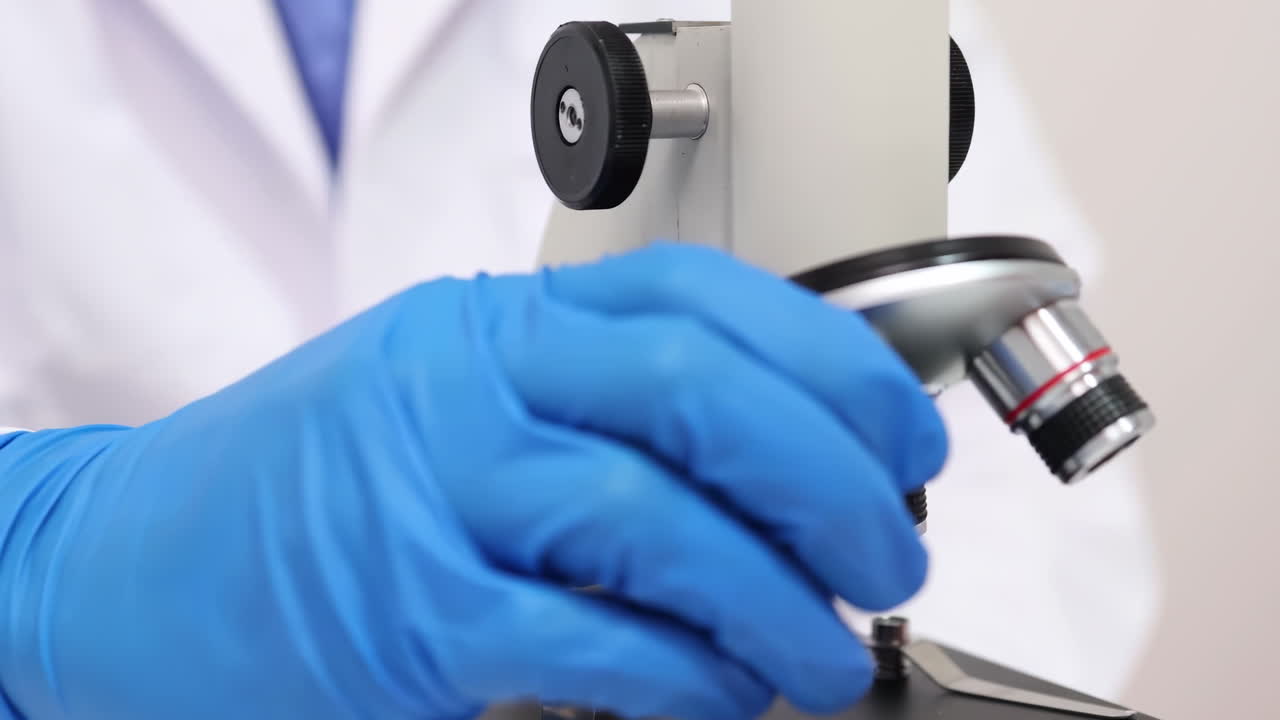 A scientist works tirelessly examines samples through a microscope, analyzing DNA samples under a powerful microscope, seeking new breakthroughs in gene editing