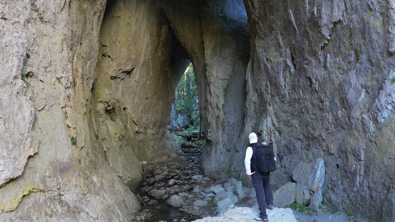 Hiker walking in the Wonderful Bridges cave near Devin, a rock formation in the Rhodope Mountains, Bulgaria