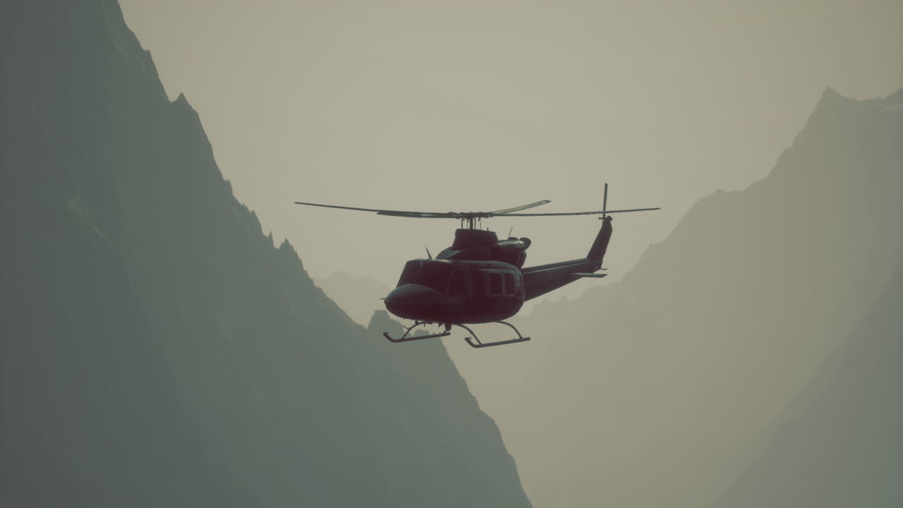 Hélicoptère survolant des montagnes majestueuses au coucher du soleil, sous une douce lumière
