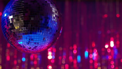 close up of mirrorball in night club or disco with sparkling lights in background