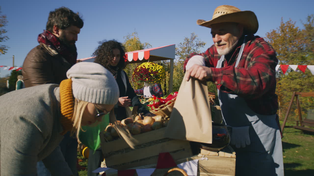 People Shopping at Local Farmers Market People Shopping Choosing Fruits and Vegetables at Local Farmers Market Packing Goods in Eco Bags Autumn Fair on Weekend Outdoors Vegetarian and Organic Food Agriculture Points of Sale system