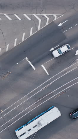 large crossroads in the city. cars, trams cross road. automobile traffic of urban transport.. aerial drone top view. vertical video