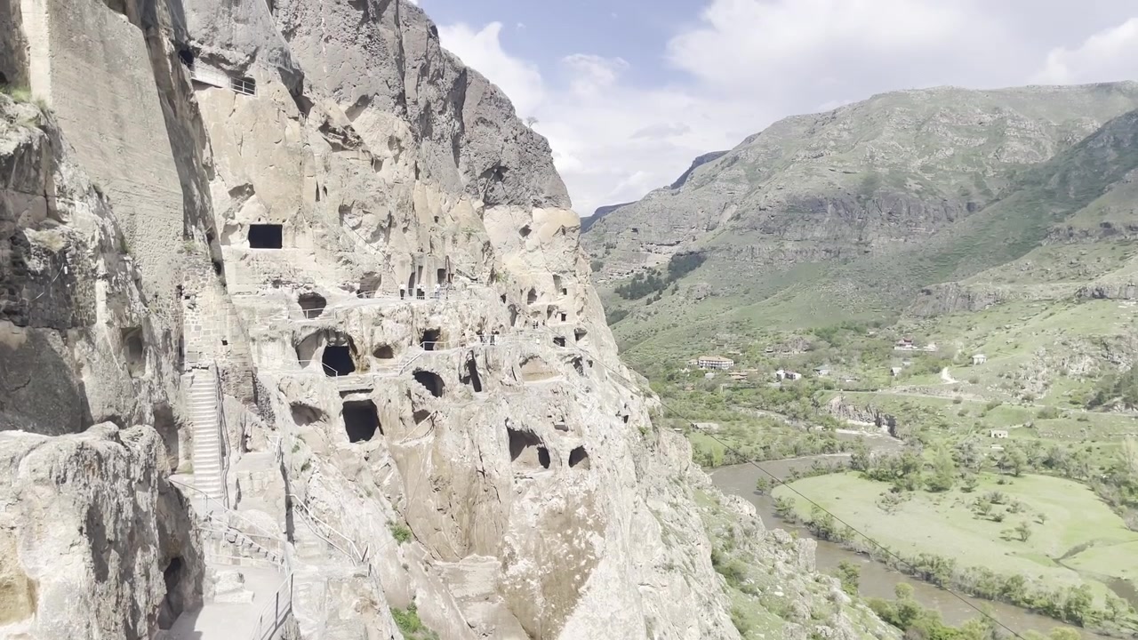 Gruzie. Záběr z podhledu s náklonem nahoru na starobylý jeskynní klášter Vardzia vytesaný do úbočí hory Erusheti