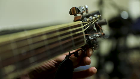 a man tunes a guitar - close up