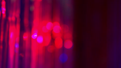 defocused close up shot of sparkling tinsel curtain in night club or disco with flashing strobe lighting 3