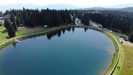 Lake-in-Rogla-mountain-sport-resort-in-Slovenia-during-springtime,-Aerial-flyover-shot