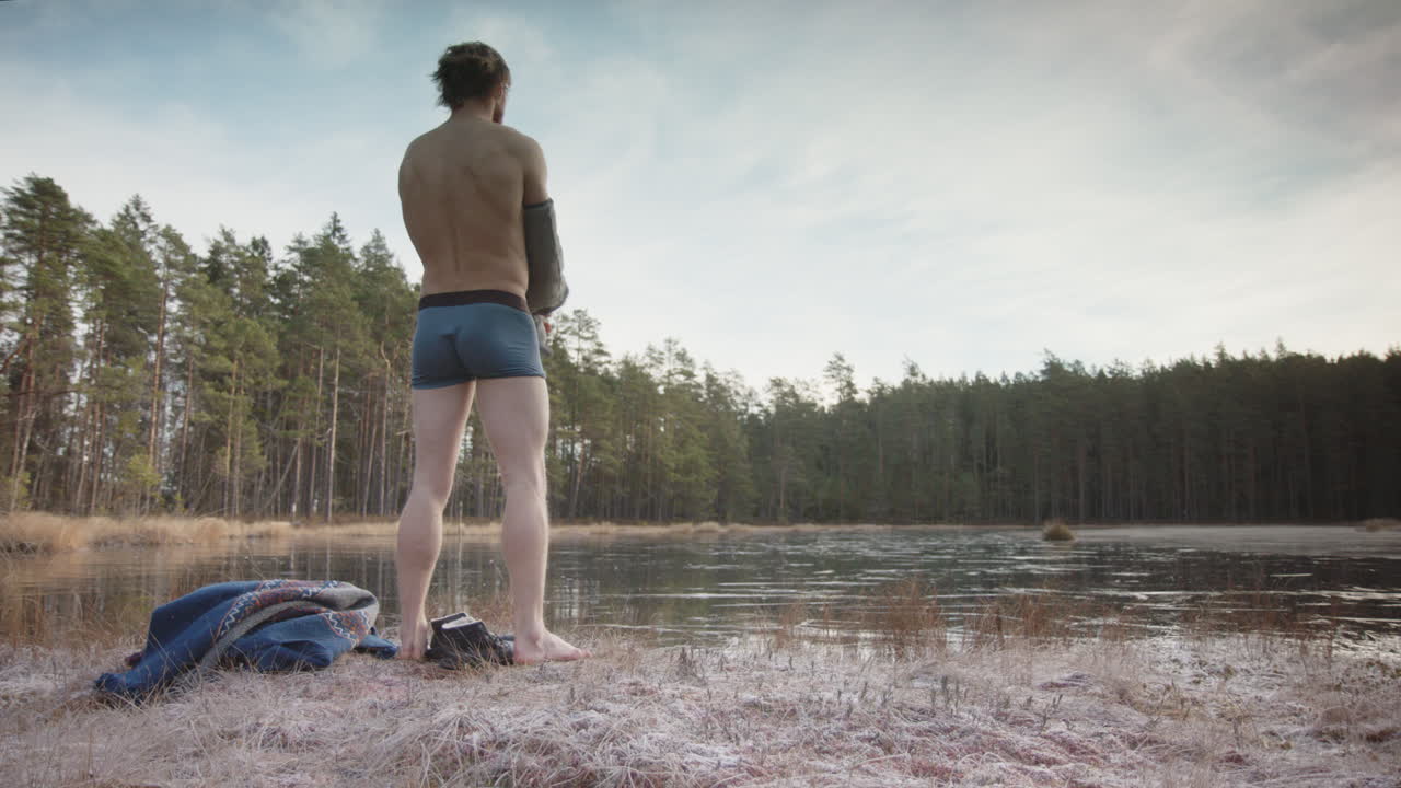 слайдер - подтянутый, мускулистый атлетический ледяной купальщик снимает топик и готовится к входу