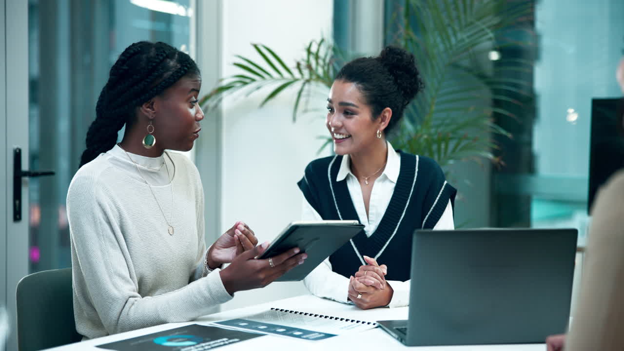 Réunion d'affaires avec des femmes diverses discutant du travail à l'aide de la technologie