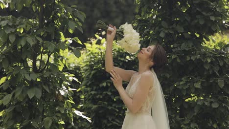 hermosa novia en un vestido blanco sonriendo y sosteniendo un ramo de flores