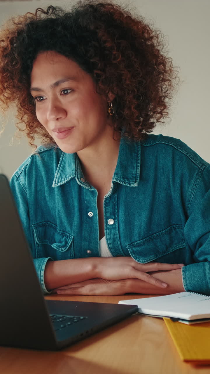 Young Woman Working on Laptop and Taking Notes at Home