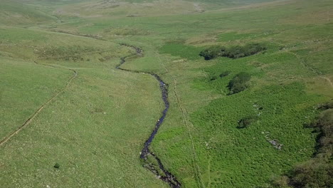 Aéreo-De-Toma-Amplia-Que-Avanza-Sobre-El-Bosque-De-Wistman-Y-El-Río-A-Su-Lado.