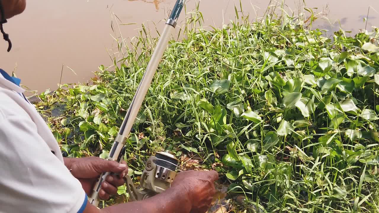 pescador tambaleándose en su captura en el río