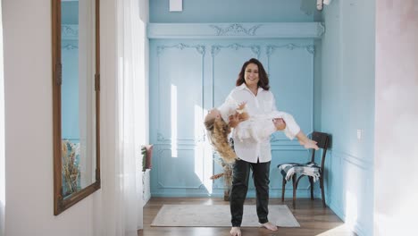 familia. mamá y hija. niña linda. mamá está dando vueltas a su pequeña princesa en un vestido de encaje blanco. mamá e hija pasan tiempo juntos, se divierten