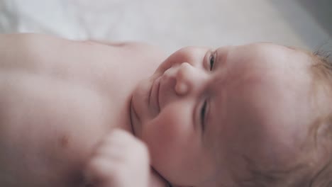 adorable newborn boy with short fair hair and blue eyes