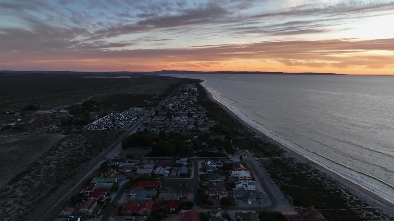Dusk flyover of small town on South African desert coast, Dwarskersbos