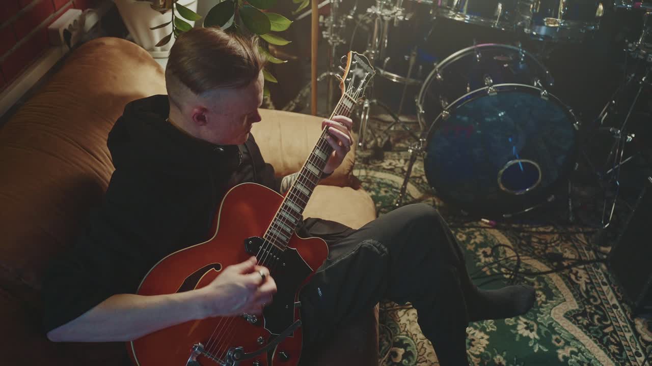 Man playing guitar in a home studio