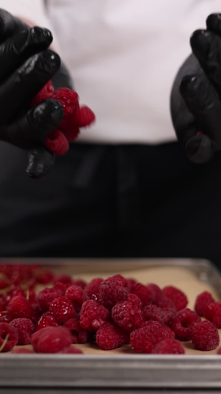 Chef preparing raspberries and red currants for baking